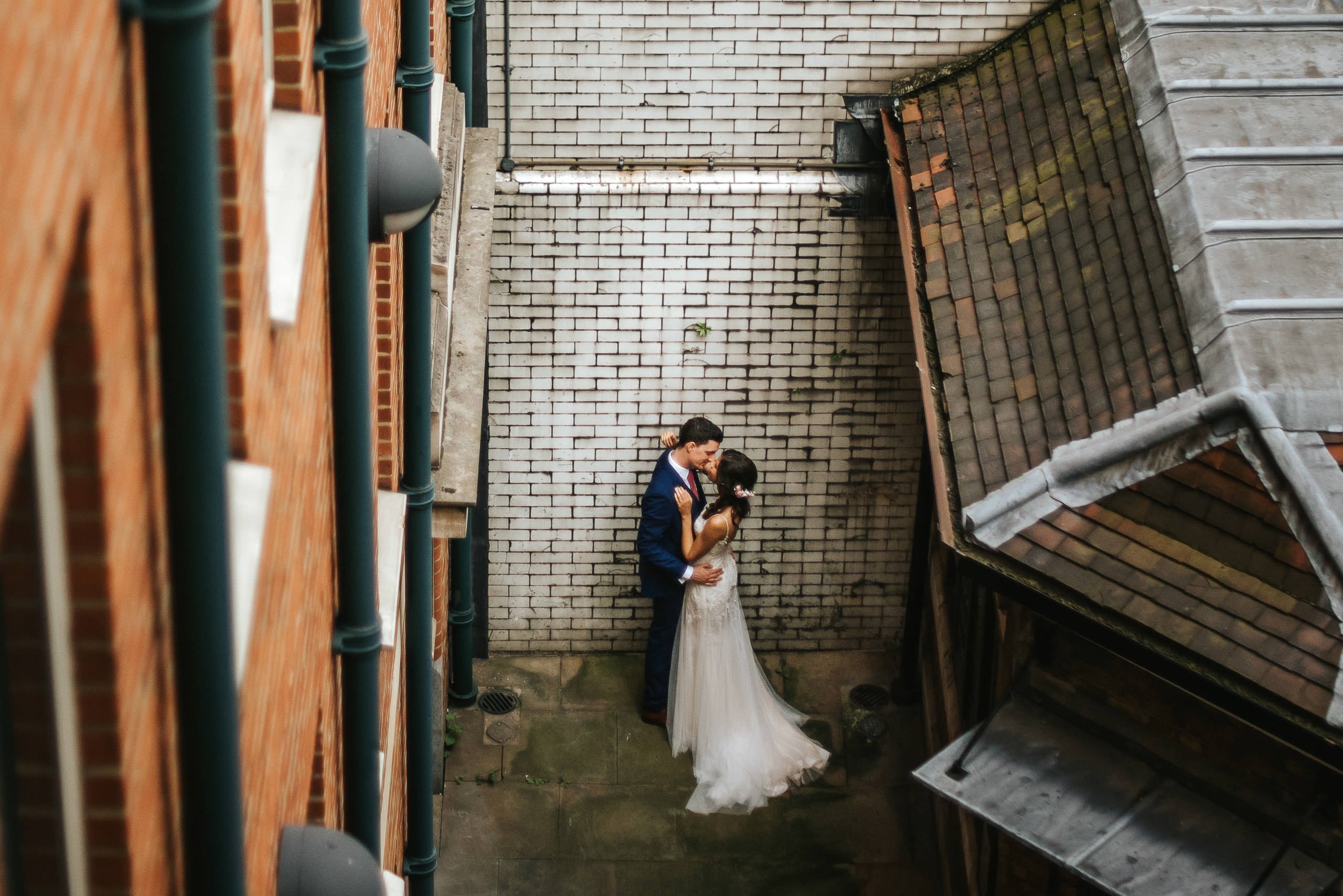 nelyweds kissing in the corner of the street by london wedding photographer
