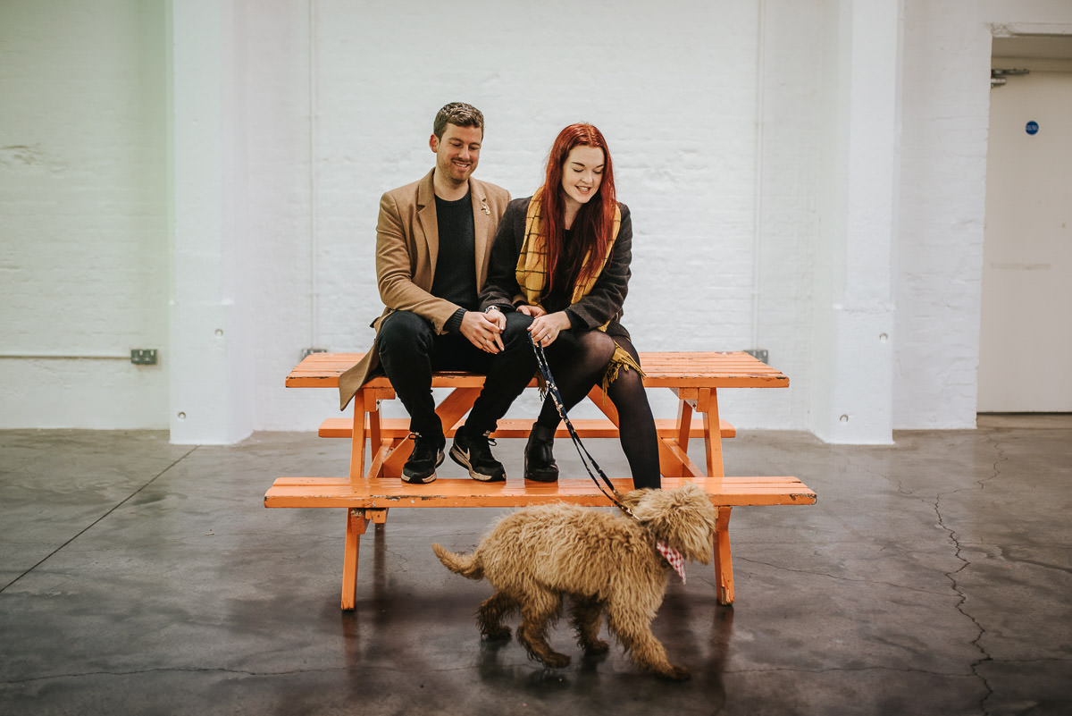 couple in brick lane on a bench with a dog