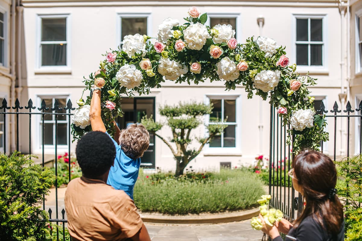 guestts preparing flower arch, wedding decoration idea