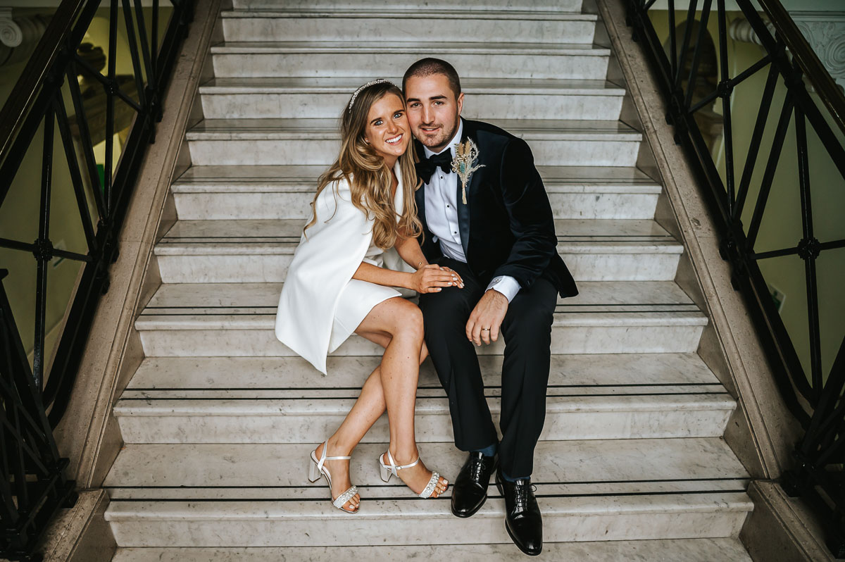 islington town hall wedding couple posing on the stairs