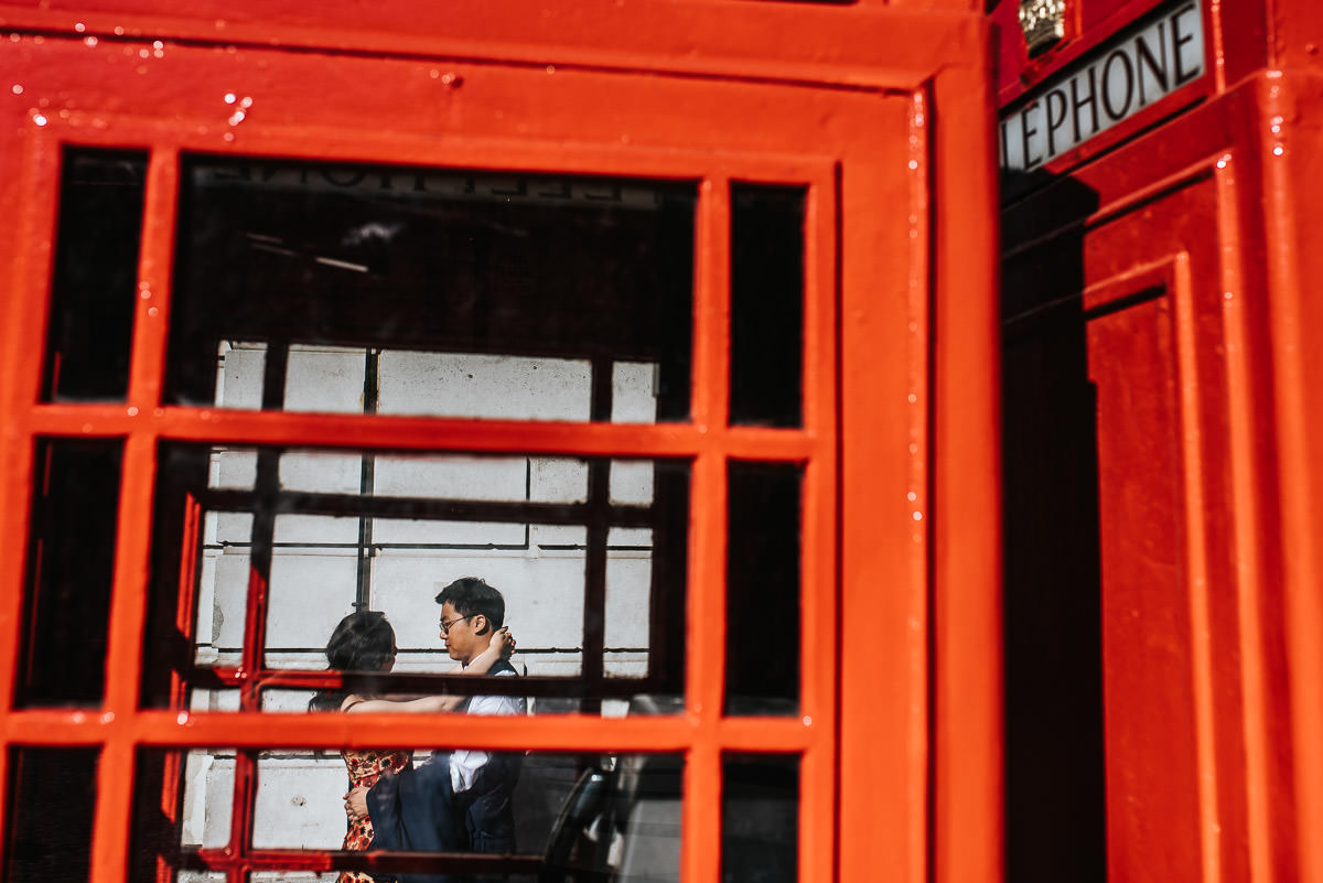 london engagement photography covent garden embracing next to red phone booth