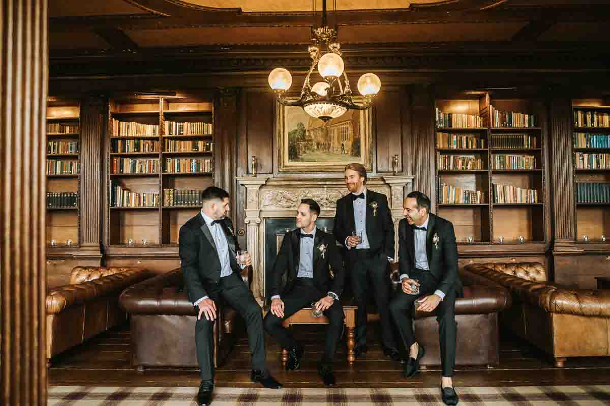 gosfield hall wedding groomsmen posing in the library