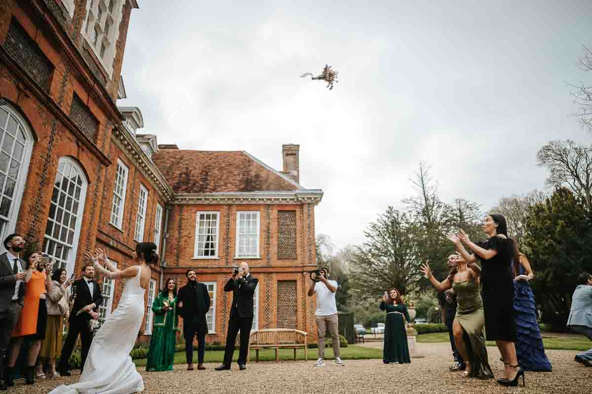 gosfield hall wedding bride throwing the flowers