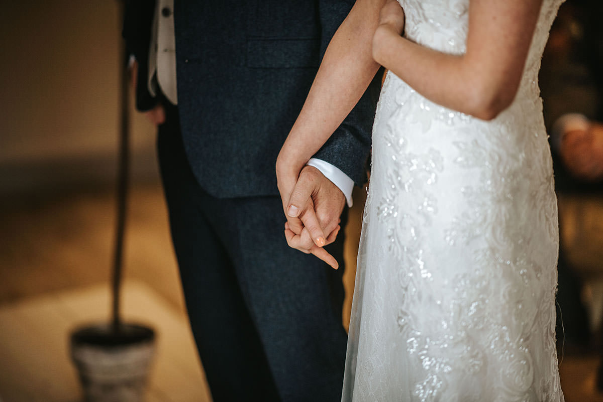 sopley mill wedding ceremony bride and groom holding hands