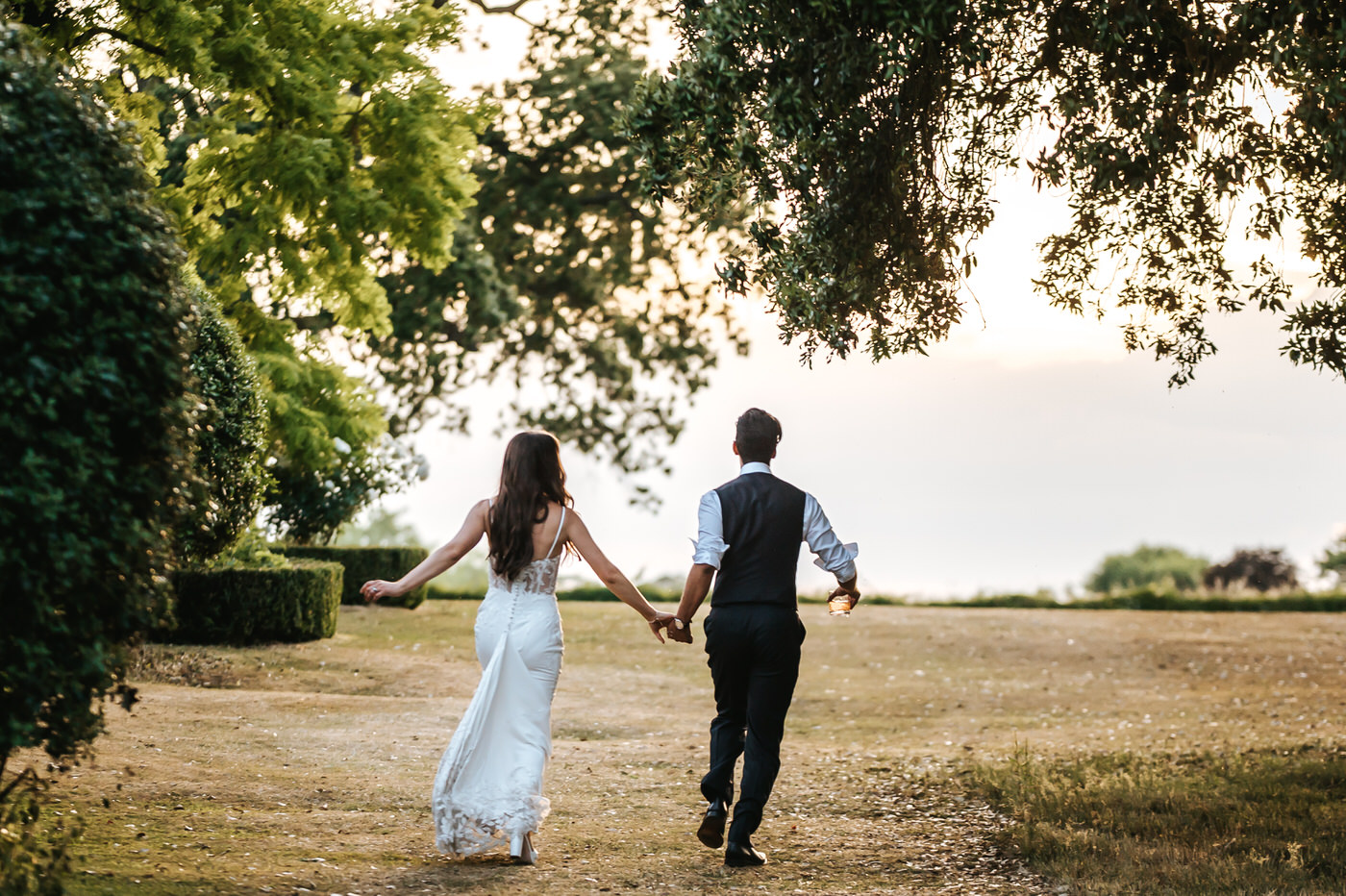 braxted park wedding bride and groom running through filed