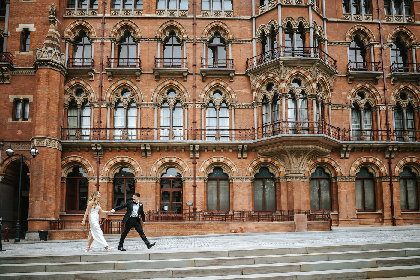 Camden Town Hall wedding couple shoot on nearby London streets couple walking in front of kings cross station