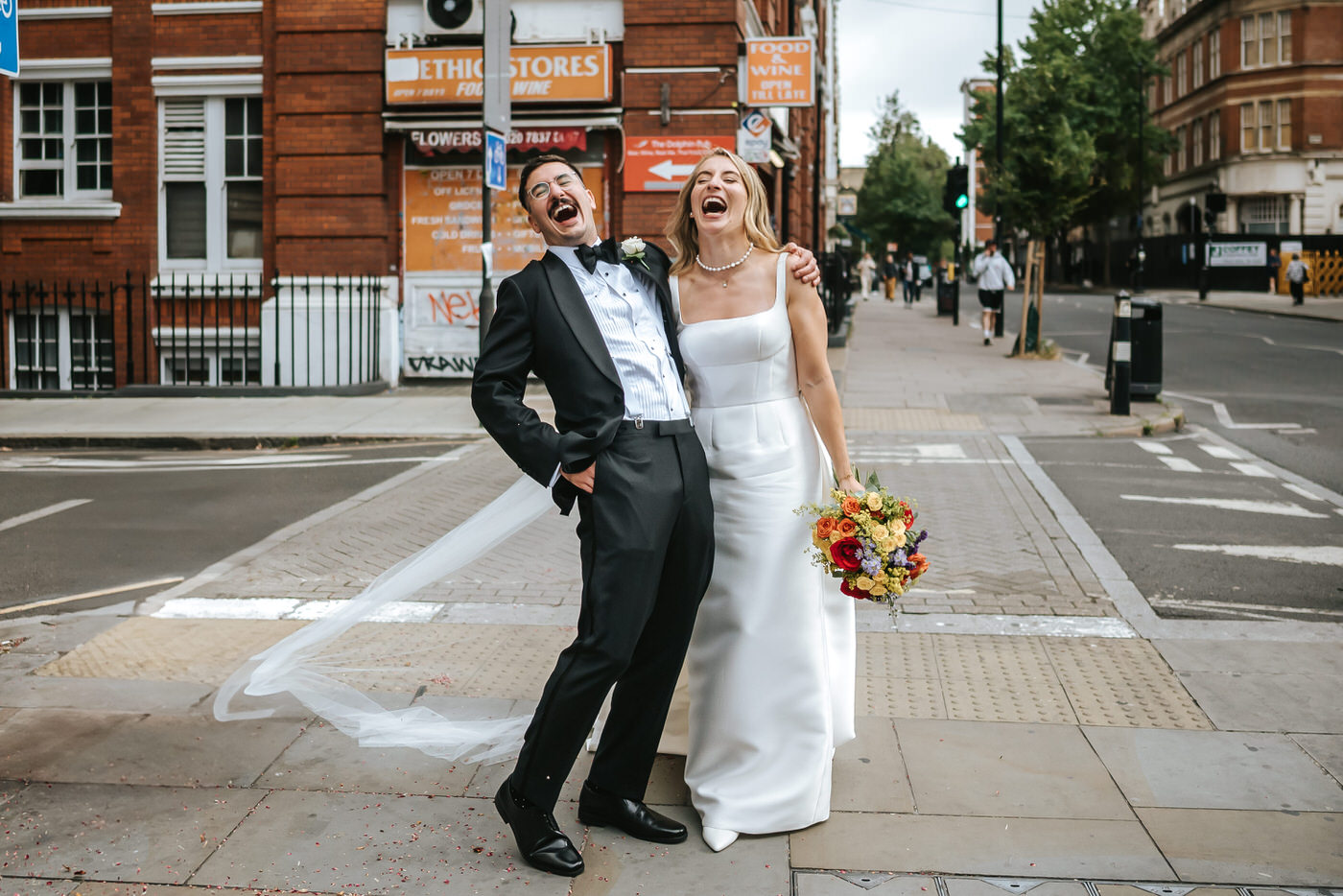 Camden Town Hall wedding newlyweds laughing in frontof the camden town hall