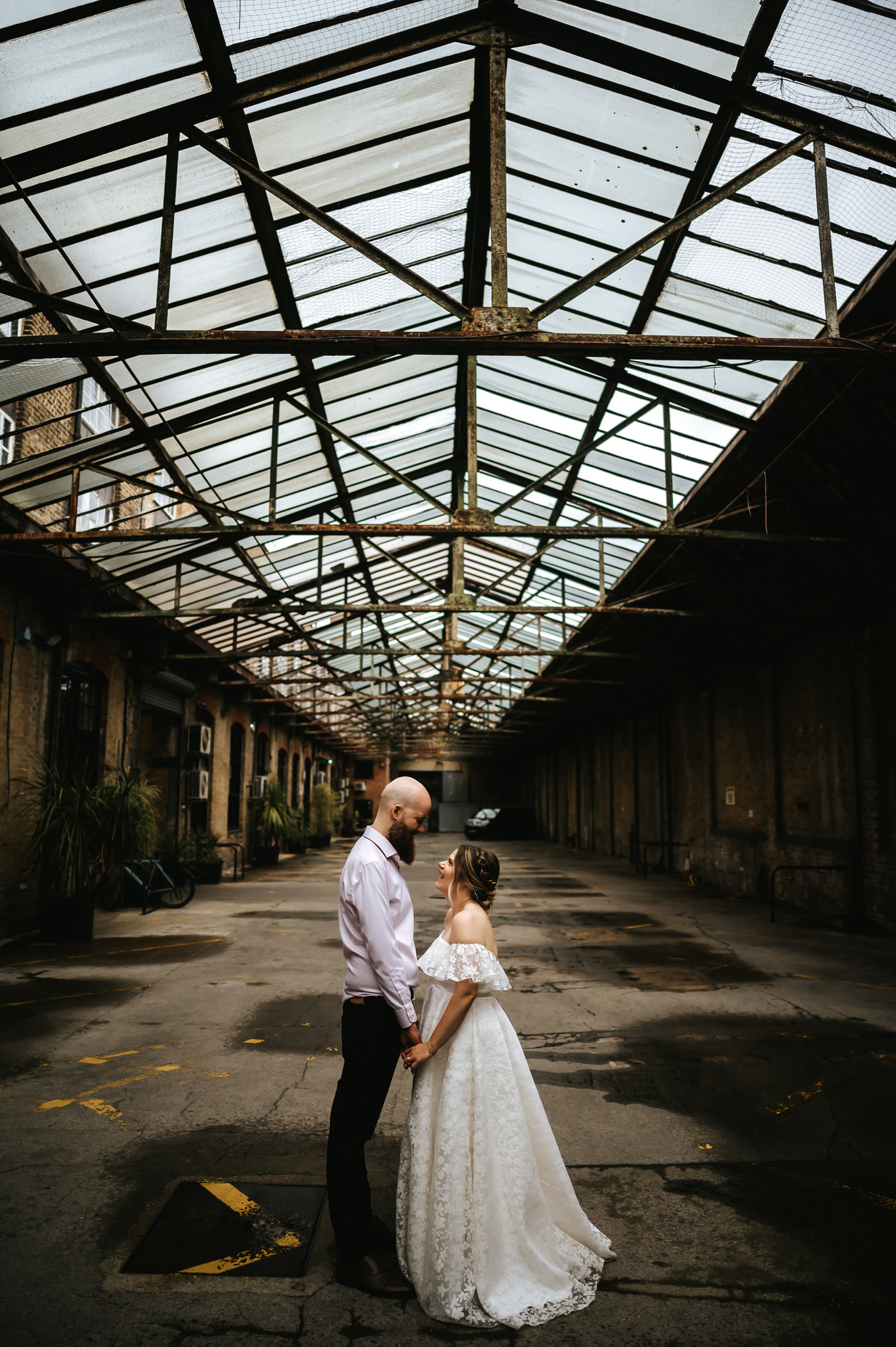 depot wedding couple hugging under glass roof