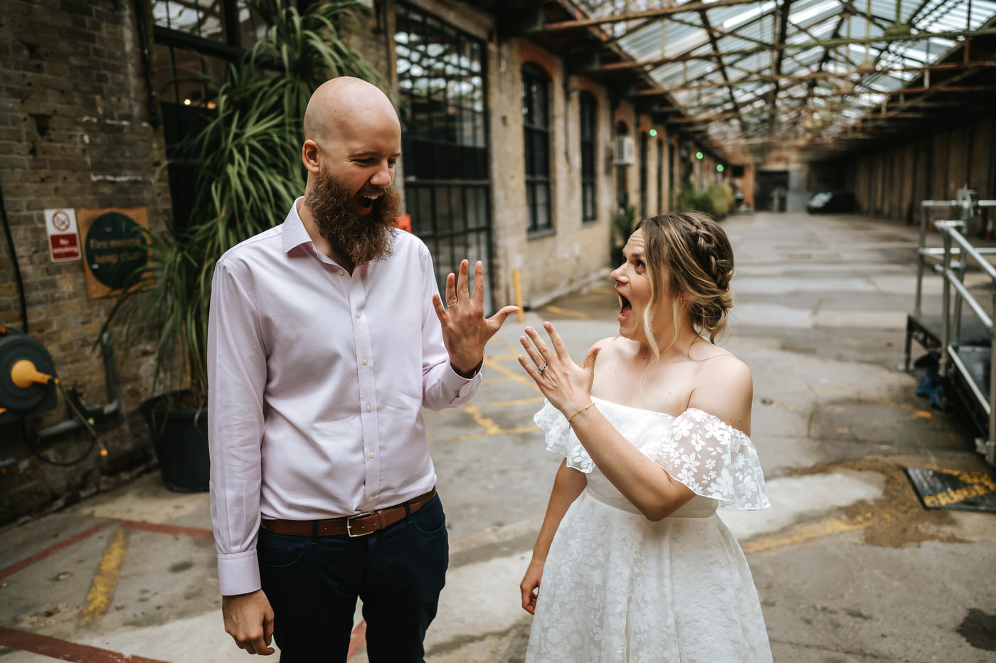depot wedding couple showing ring fingers to each other