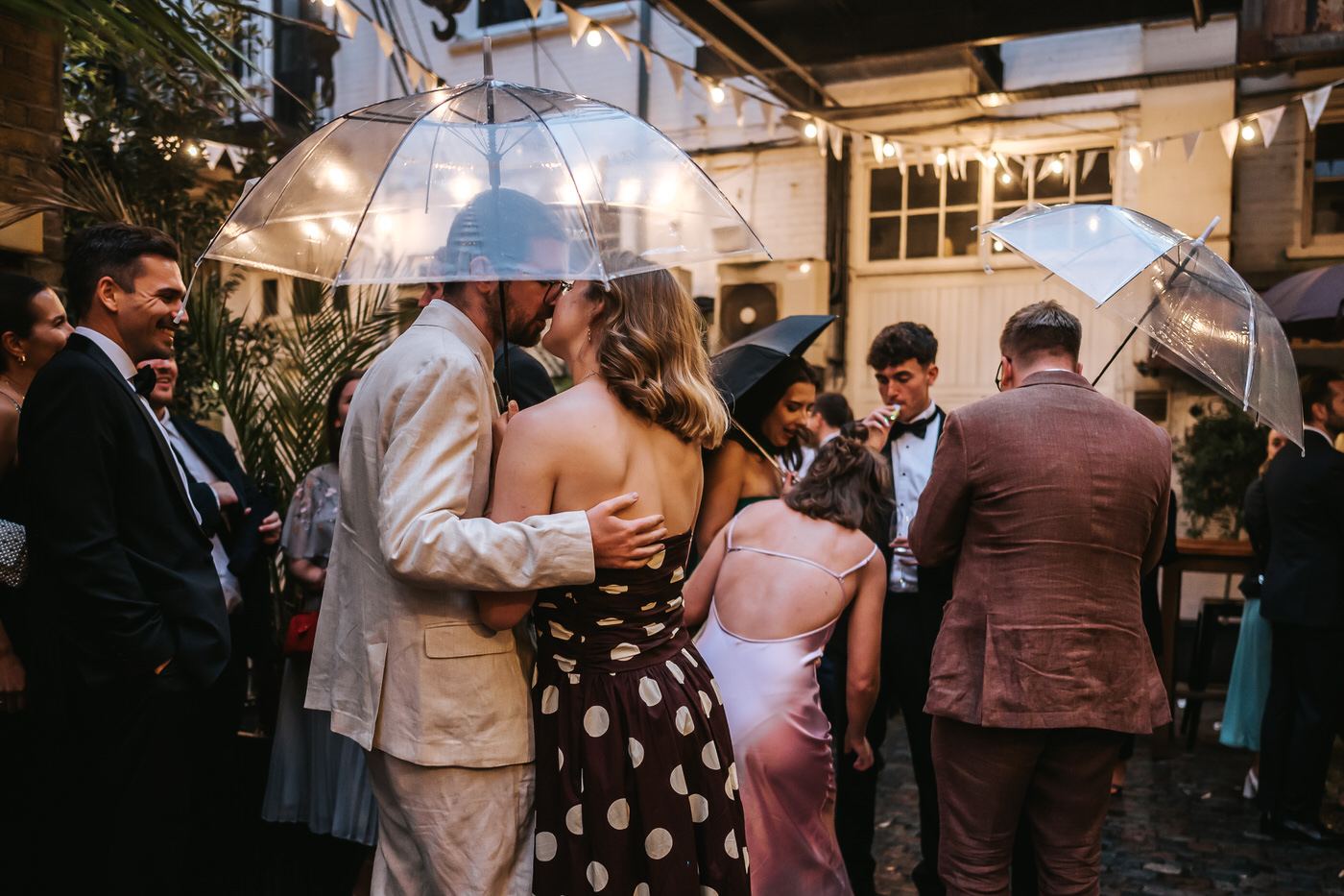 depot wedding couple kissing under umbrella