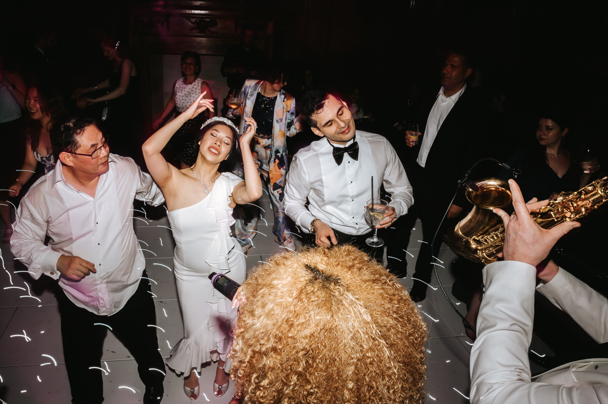 ashridge house wedding bride and grrom dancing vigourisly surrounded by wedding guests