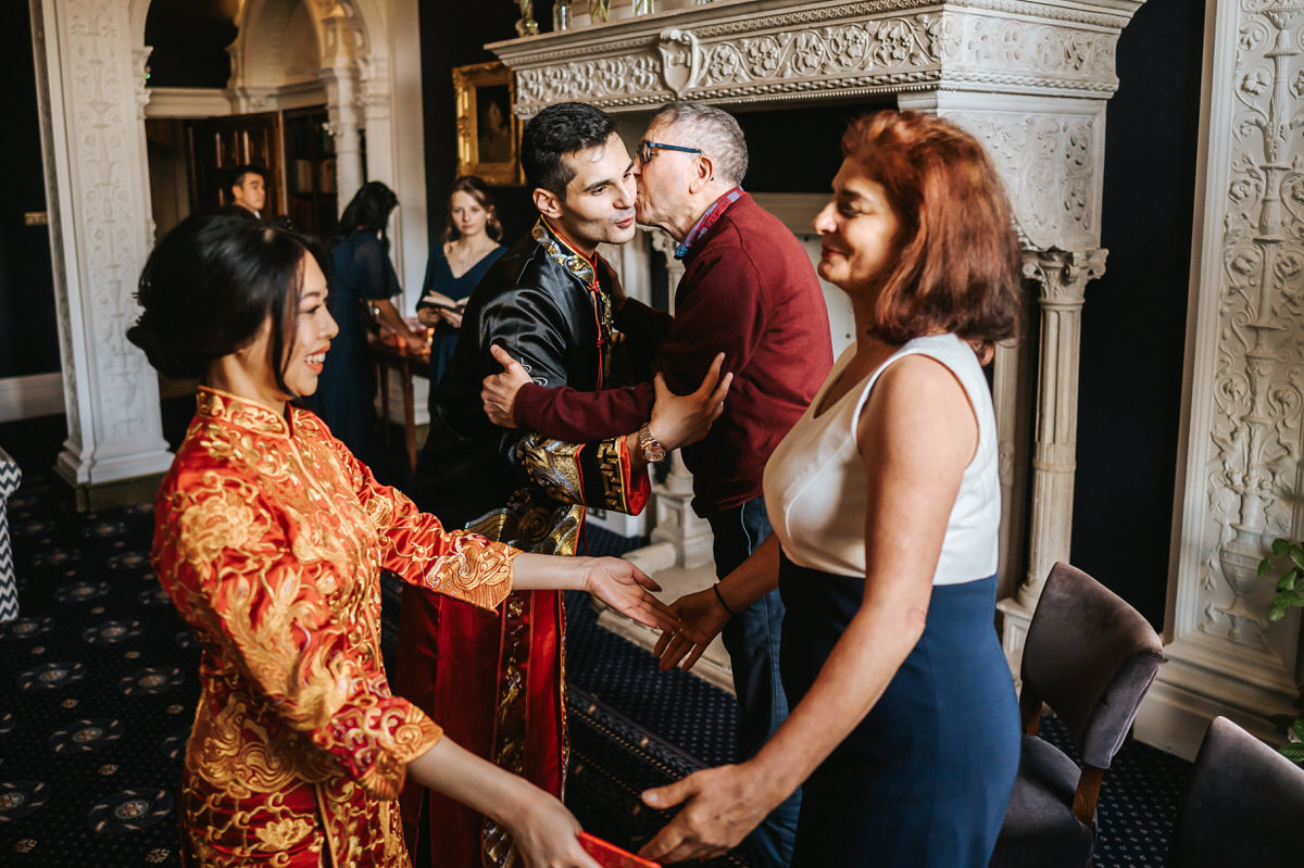 ashridge house wedding bride and groom hugging and kissing their parents