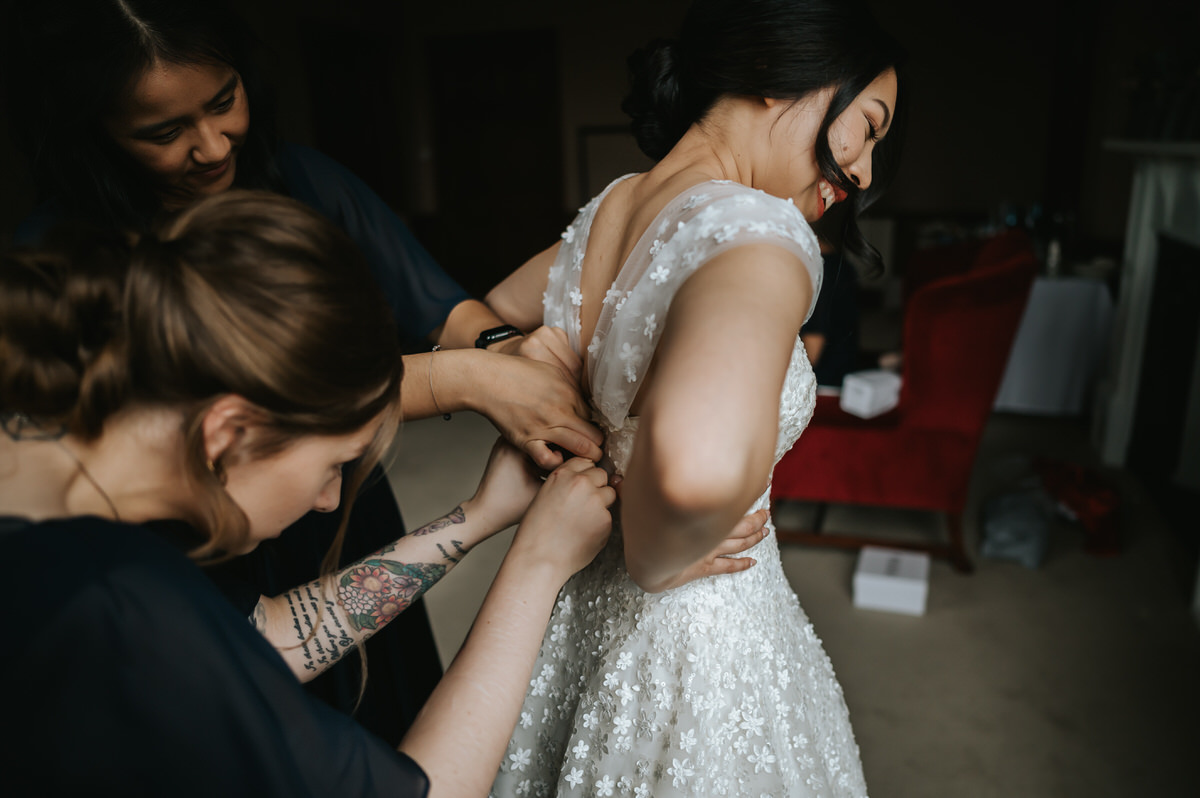 ashridge house wedding getting ready bride putting the dress on