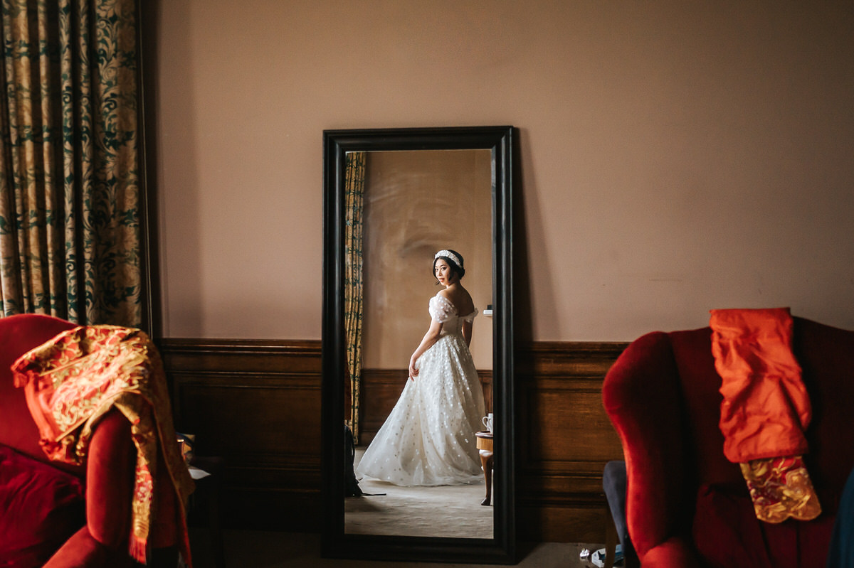 ashridge house wedding getting ready bride checking herself in the mirror