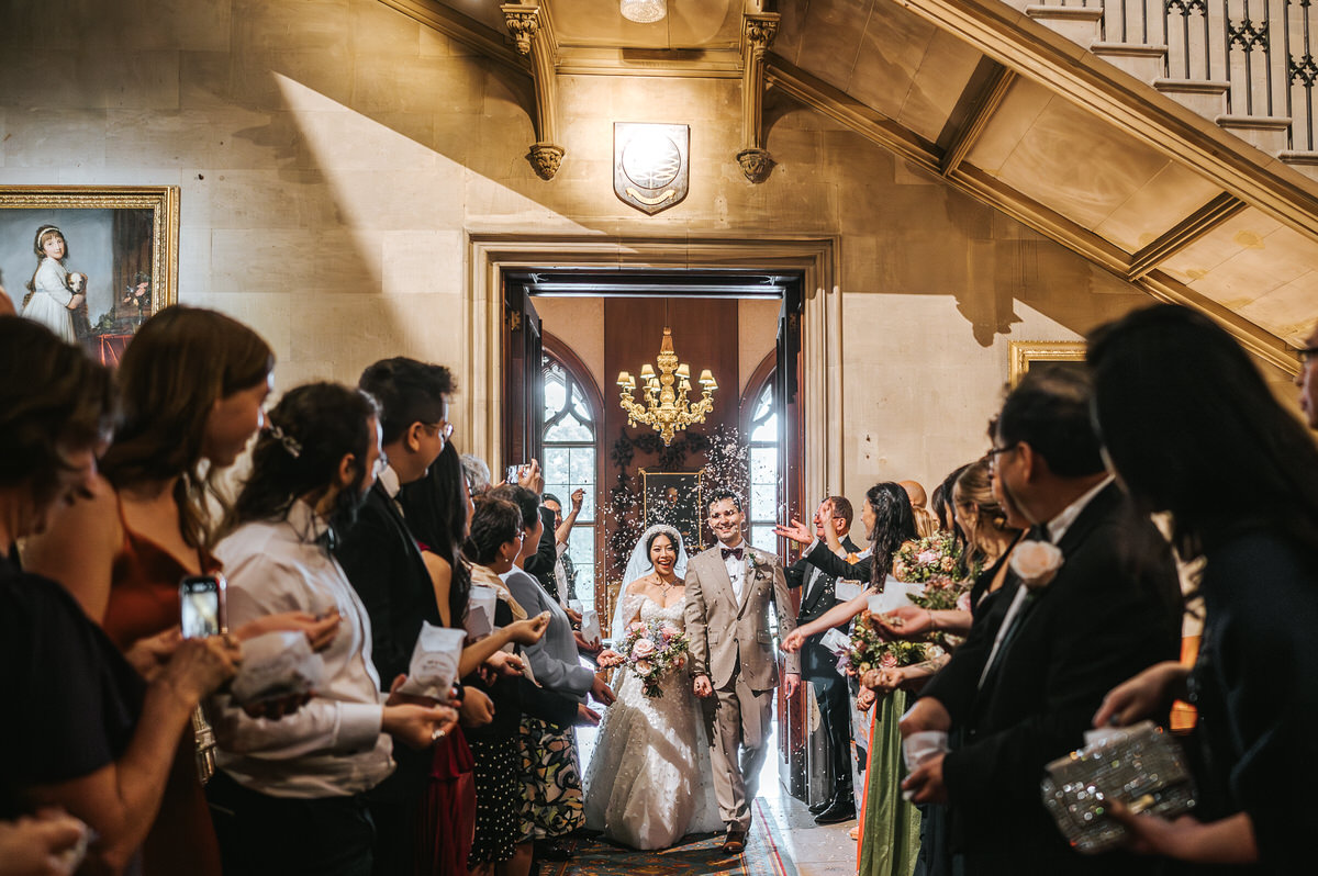 ashridge house wedding confetti being thrown on newlyweds by the gusts on the couple