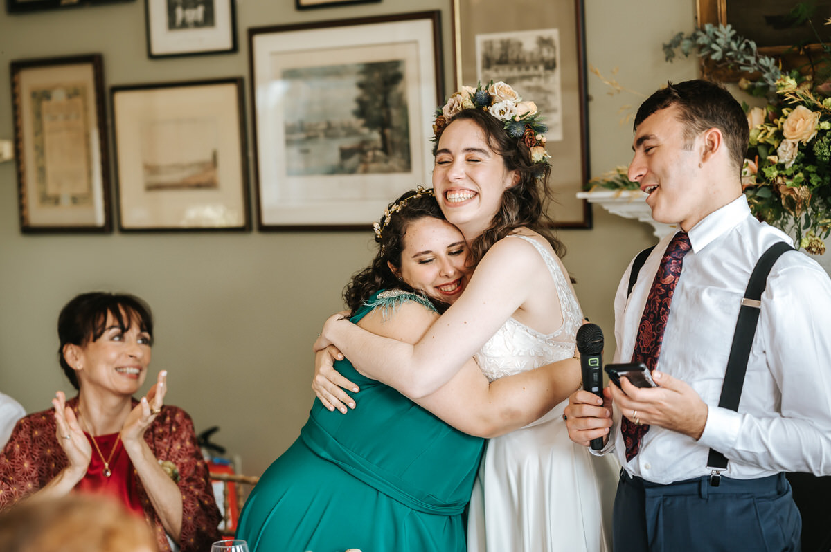 london rowing club wedding bride hugging her best friend during speeches