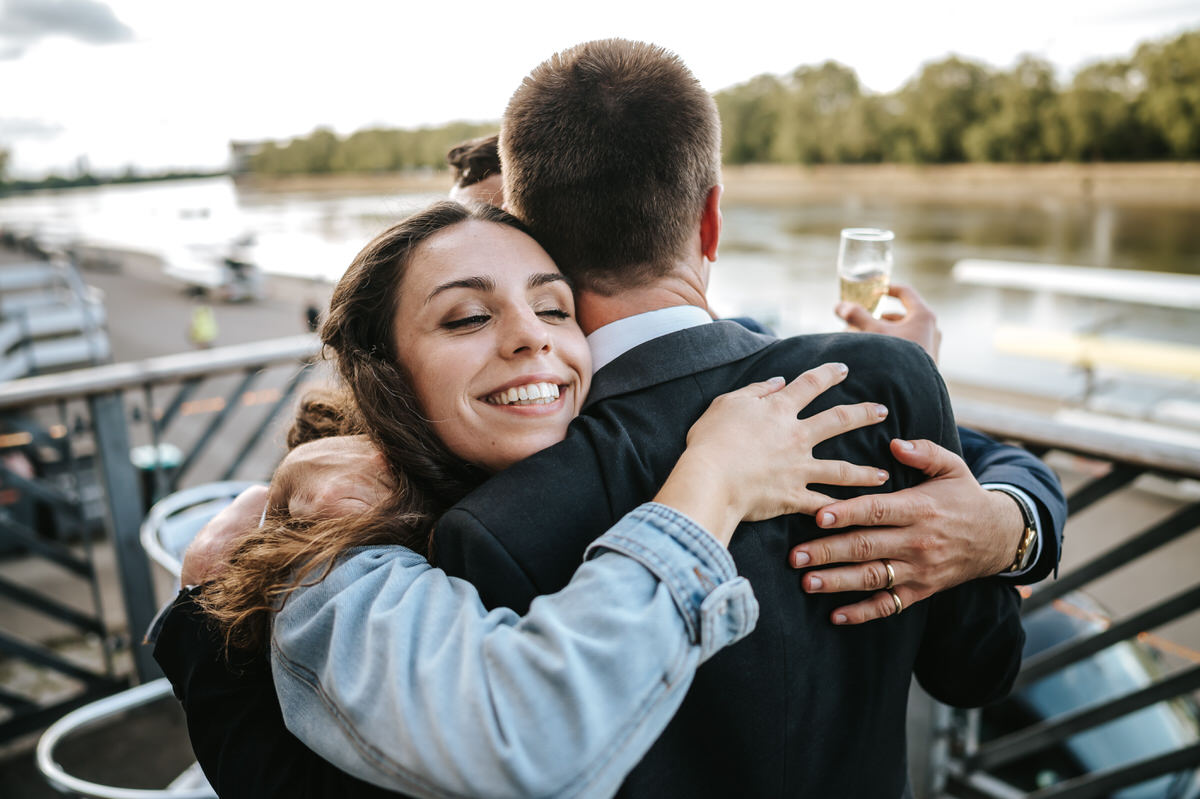 london rowing club wedding guests hugging on the balcony