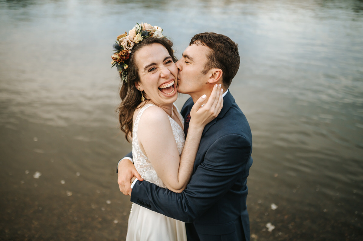 london rowing club wedding groom kissing the bride on the cheek